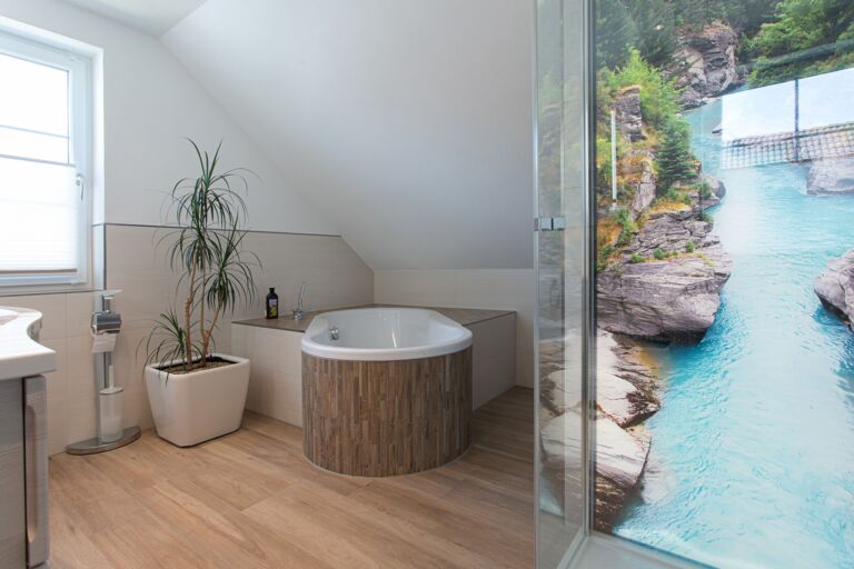 Blick auf eine moderne Badewannen-Anlage, eingefasst mit Fliesen in Holzoptik