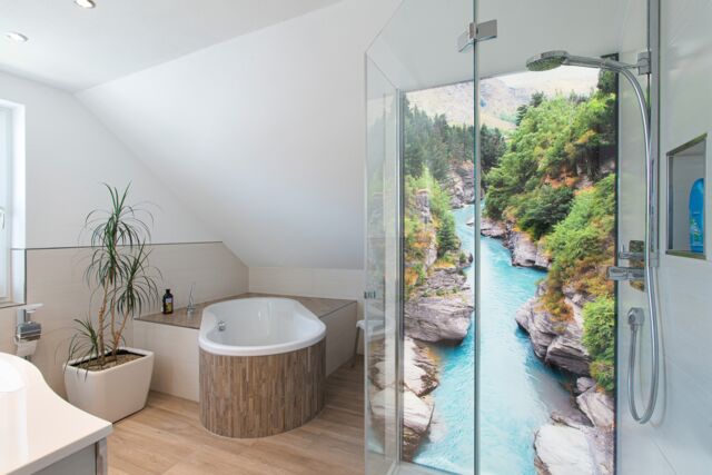Blick in ein Badezimmer mit ausgefallener Badewannen-Anlage und Dusch-Anlage mit beleuchteter Rückwand