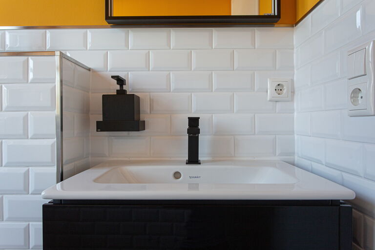 Moderne Gästewaschtisch-Lösung: weiße moderne Fliesen und dunkler Korpus