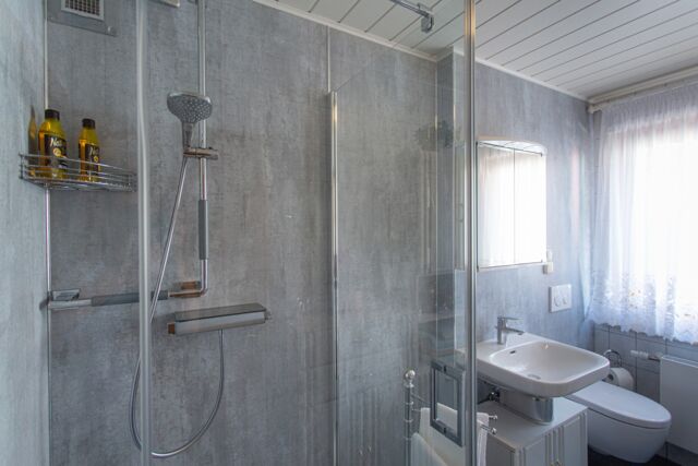 Altersgerechte Dusch-Anlage mit Glasabtrennung und pflegeleichten Dekorplatten