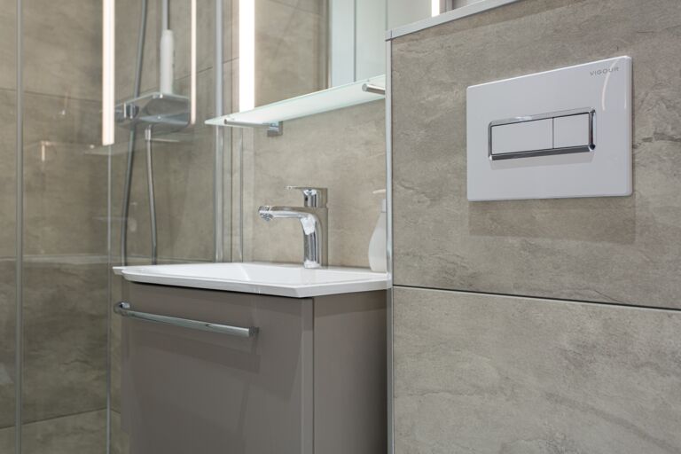 Blick auf moderne Badezimmer-Wandverkleidung mit pflegeleichte Dekorplatten in Steinoptik