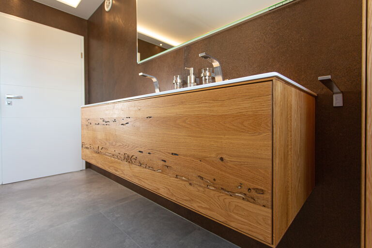 Detailaufnahme: Blick auf die Massivholz-Front einer modernen Waschtischmöbel-Anlage